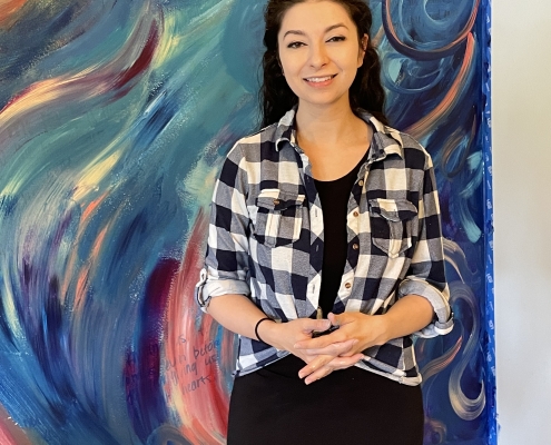 Elizabeth Londen standing in front of her beautiful swirly painted mural